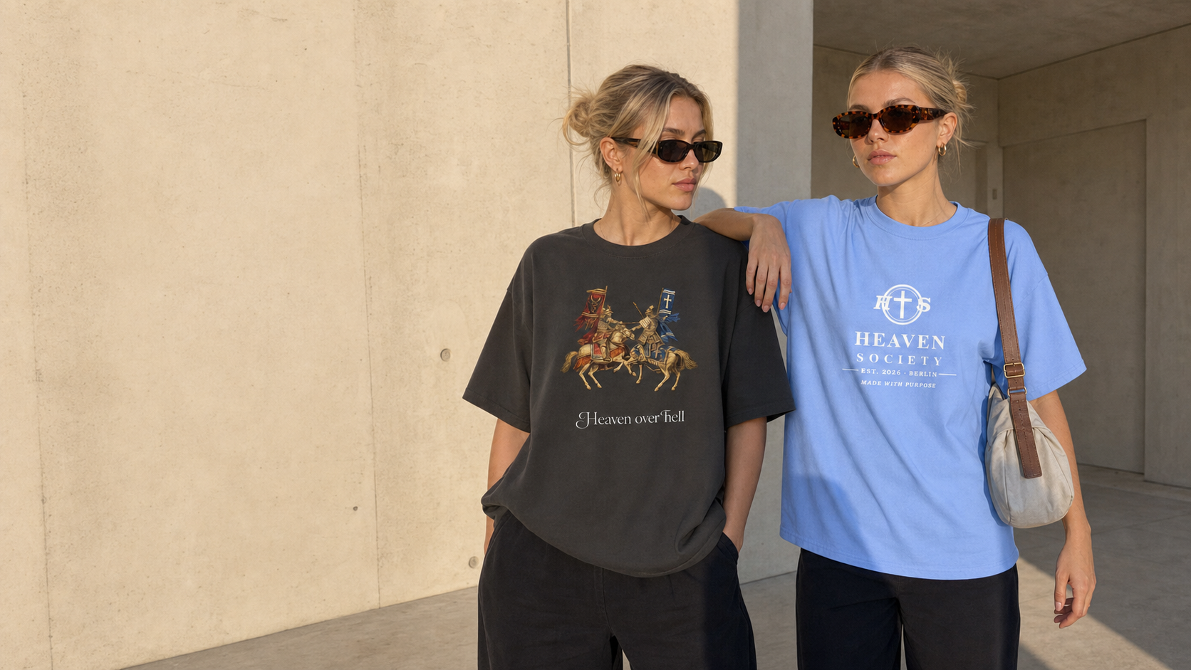 Two women wearing the Heaven over Hell Boxy Tee and the light blue Heaven Society Logo Tee
